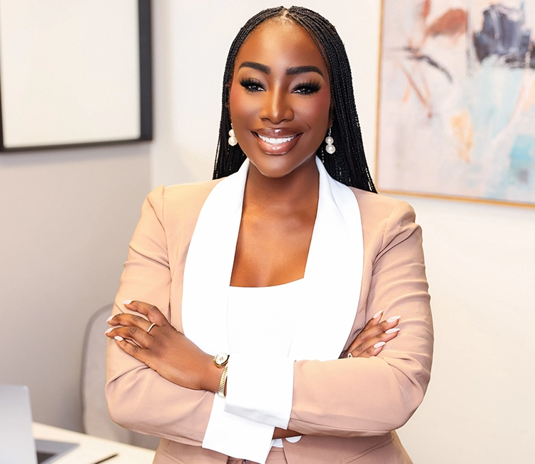 Confident attorney standing in a modern office with arms crossed and a professional demeanor.