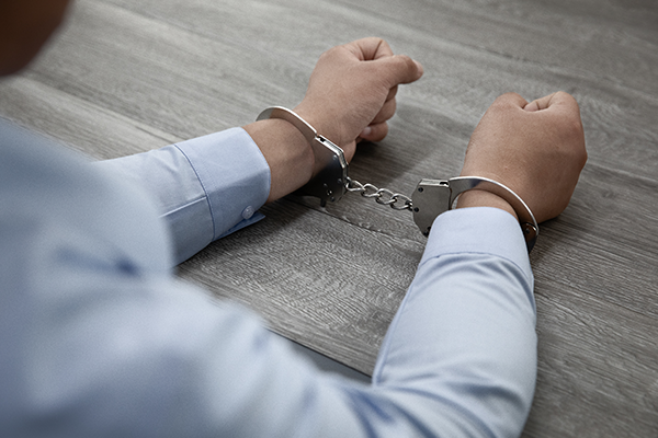 Person wearing handcuffs while facing legal consequences during a criminal case.